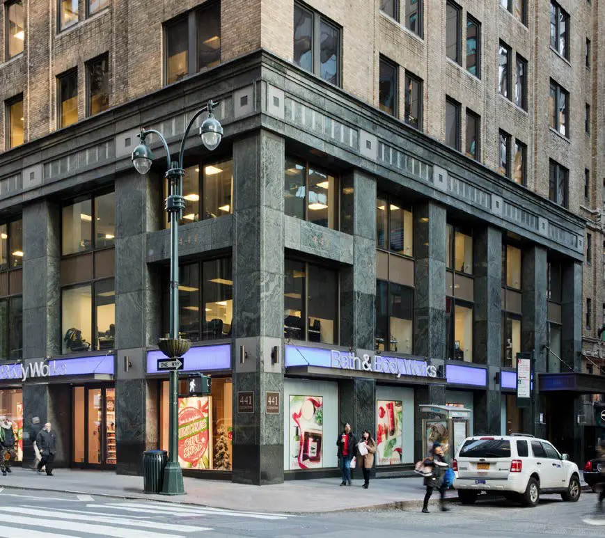 Street corner building with storefront and pedestrians.