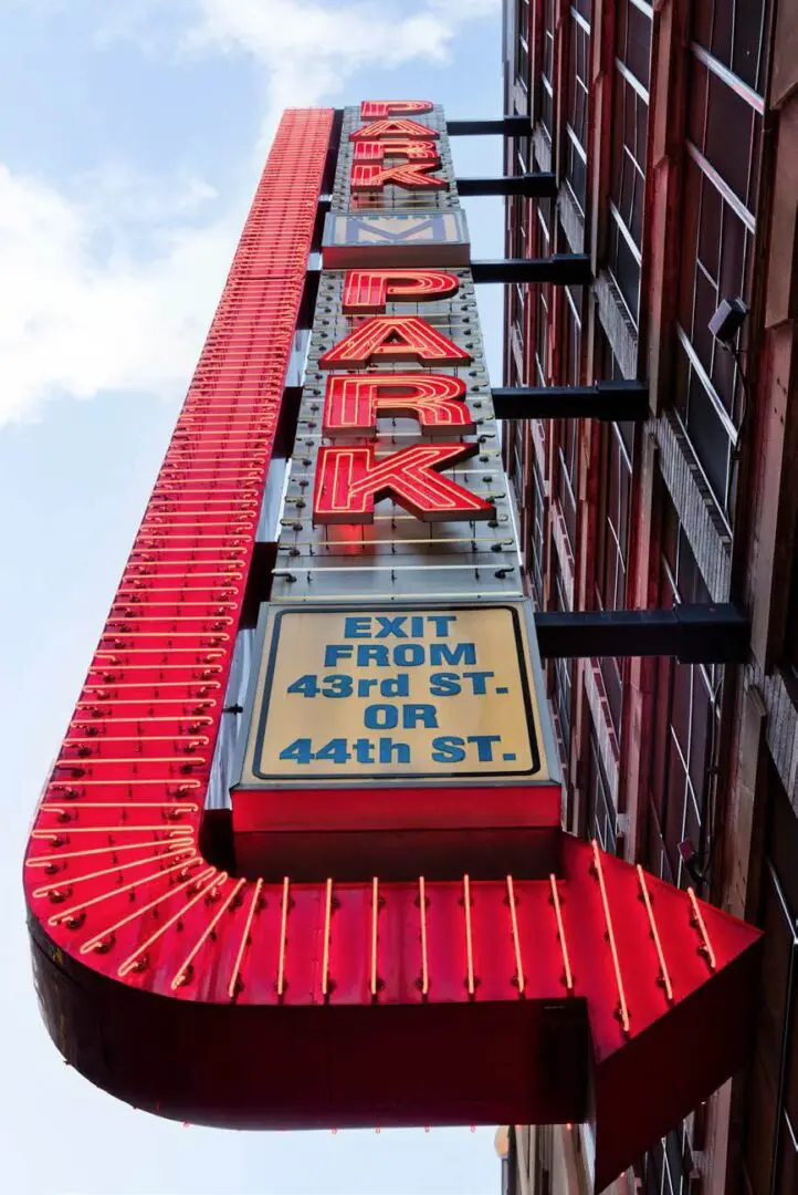 Red vertical parking sign with exit directions.