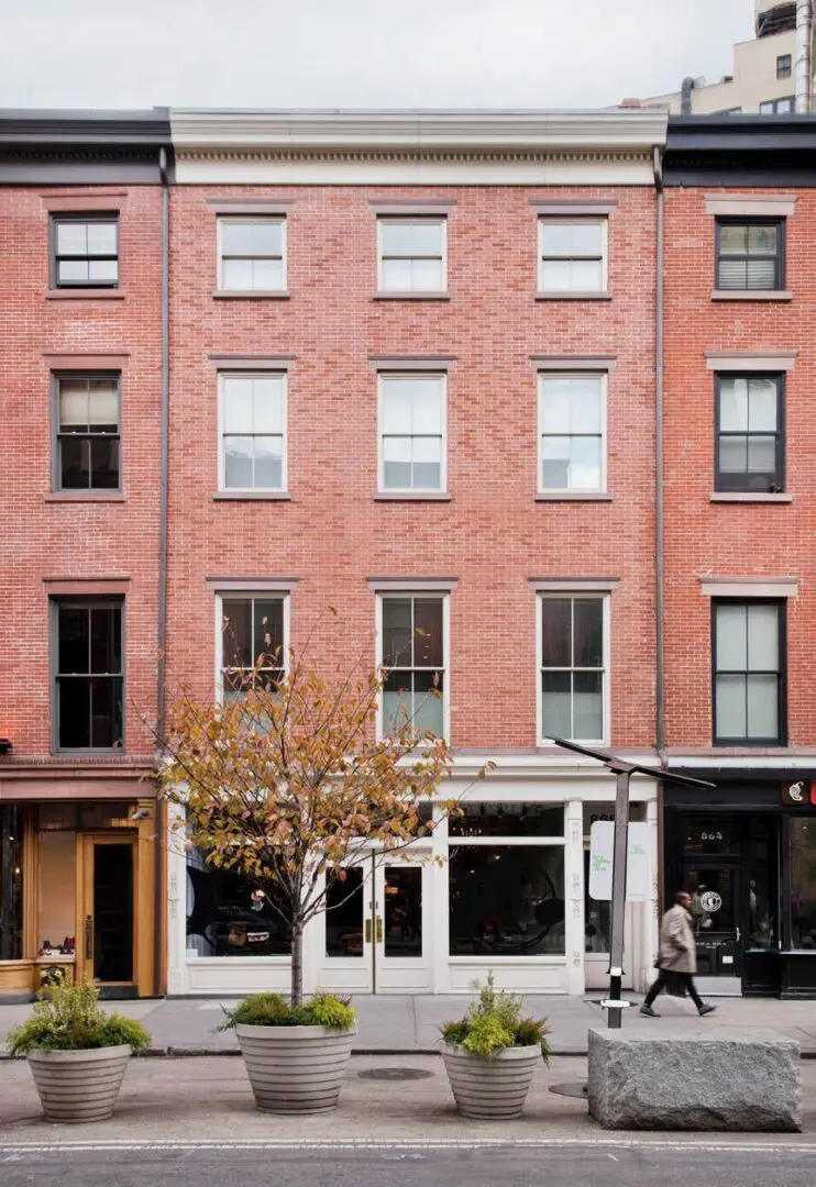 Red brick building with storefront and plants.