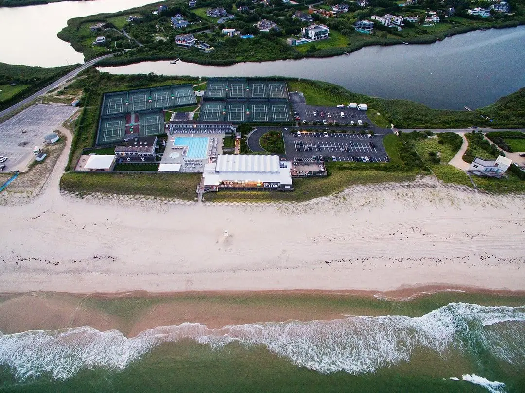 Aerial view of beachside tennis courts, buildings.