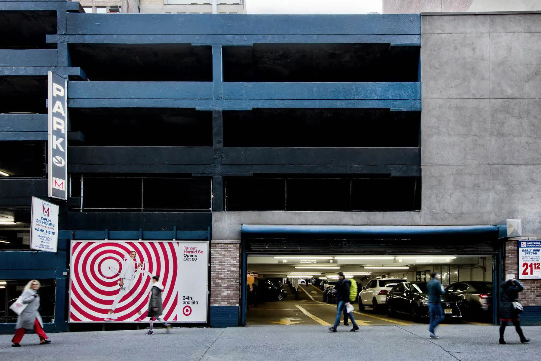 Urban parking garage with people walking outside.