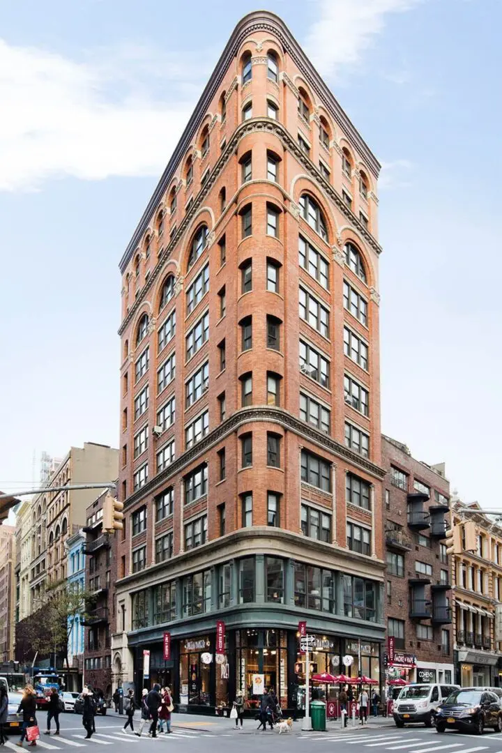 Flatiron-style building on a busy city corner.
