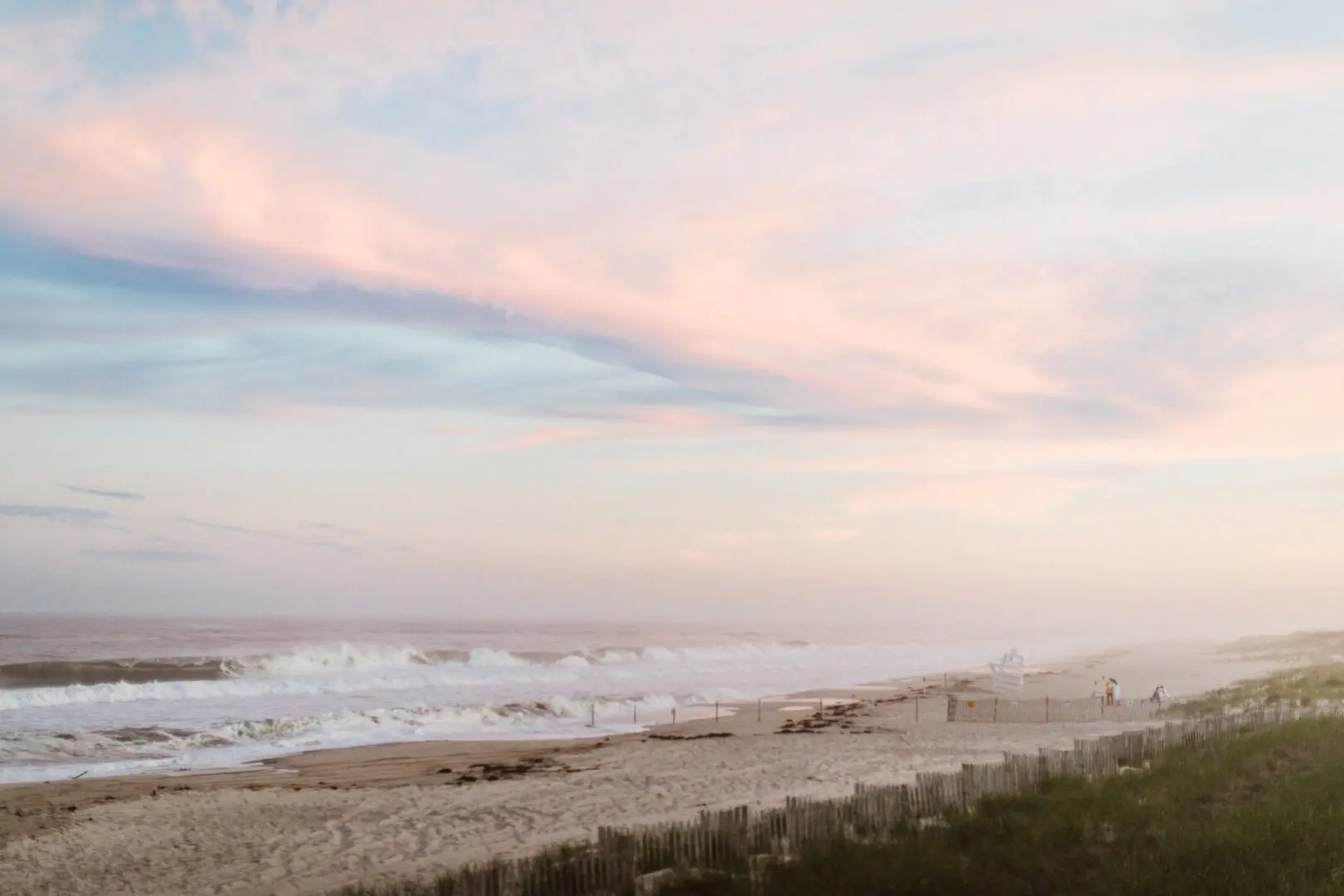 Beach at sunset with pink clouds.