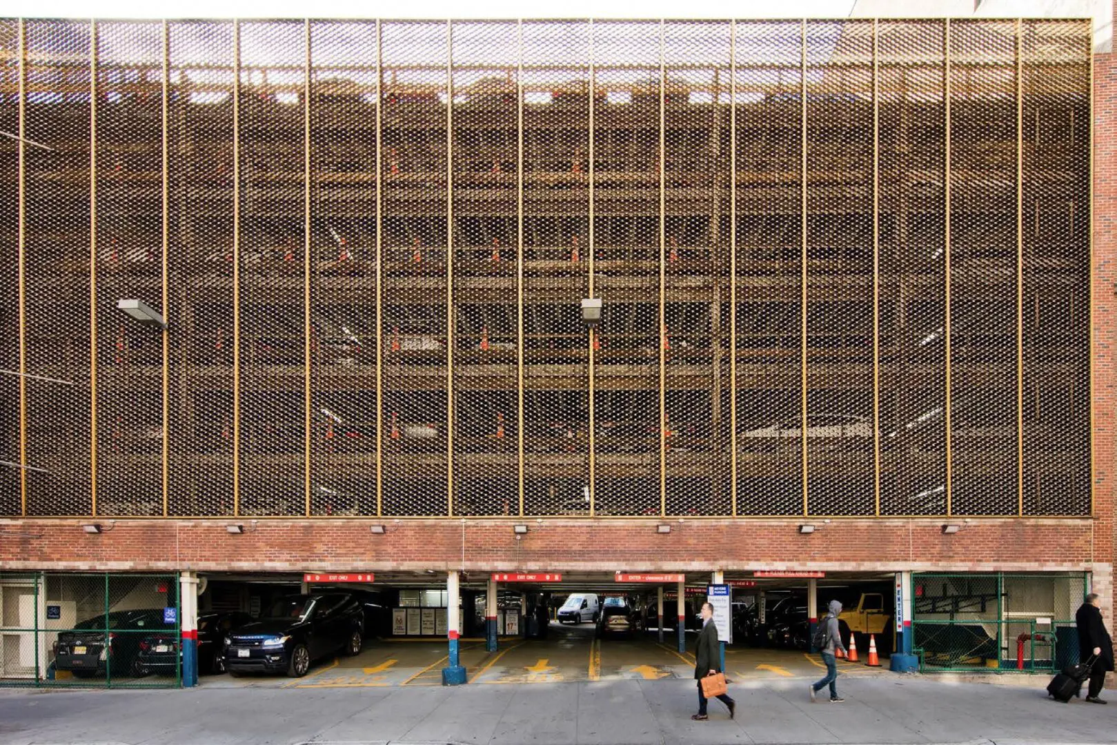 Parking garage exterior with people walking.